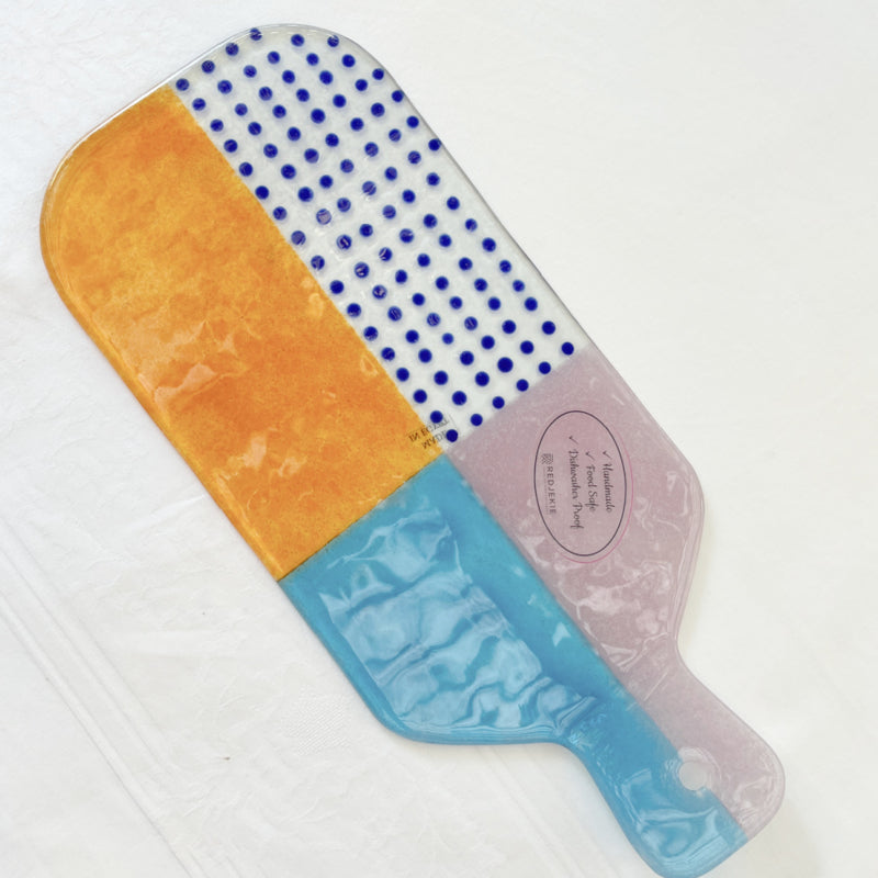 Rechthoekige glazen serveerplank met iets opstaand handvat. Lichtroze, blauw, oranje, kobaltblauw gestipt | 35 x 15 cm