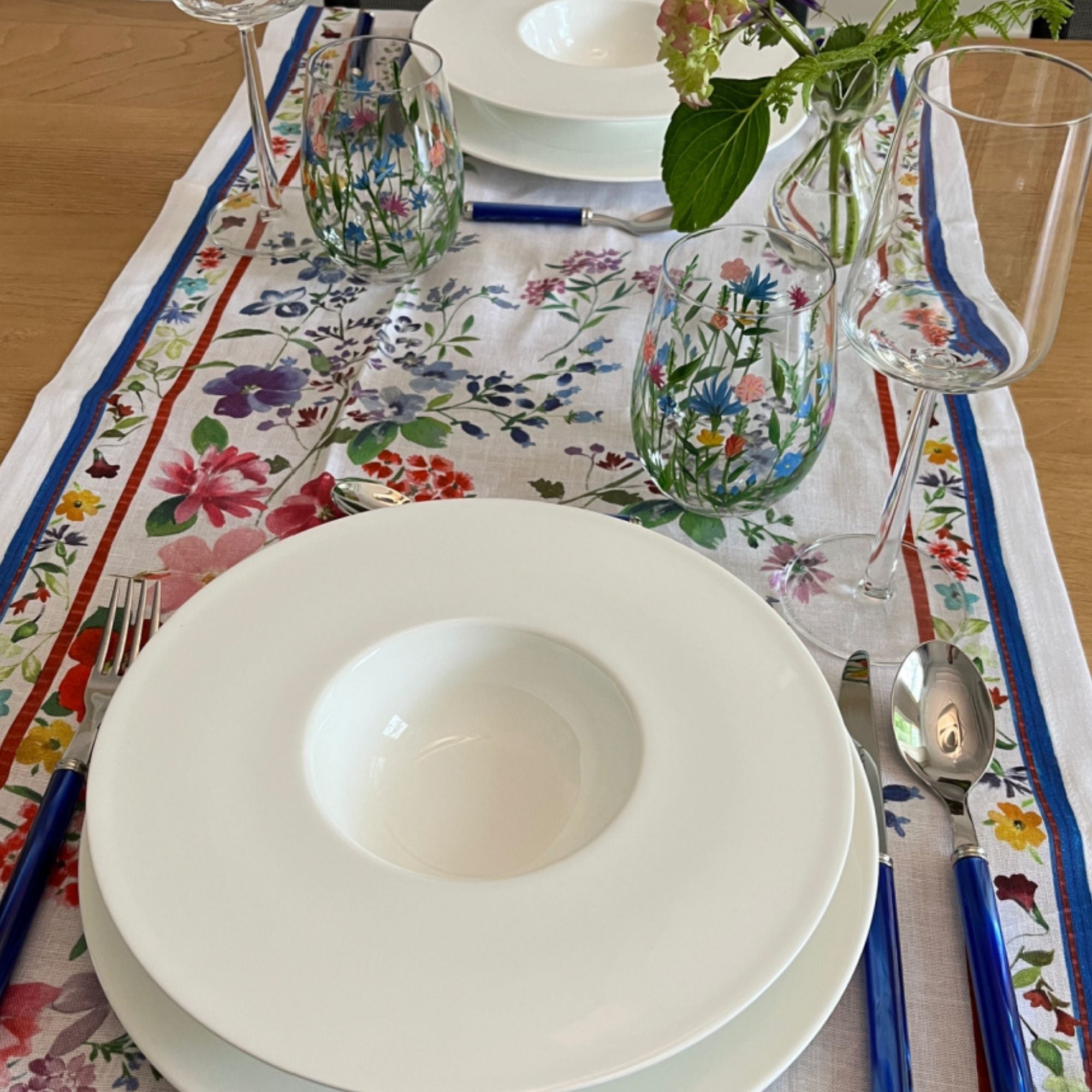 Primula tafelloper en tafelkleden met aquarel met voorjaarsbloemetjes en rood-blauwe rand, kies je formaat