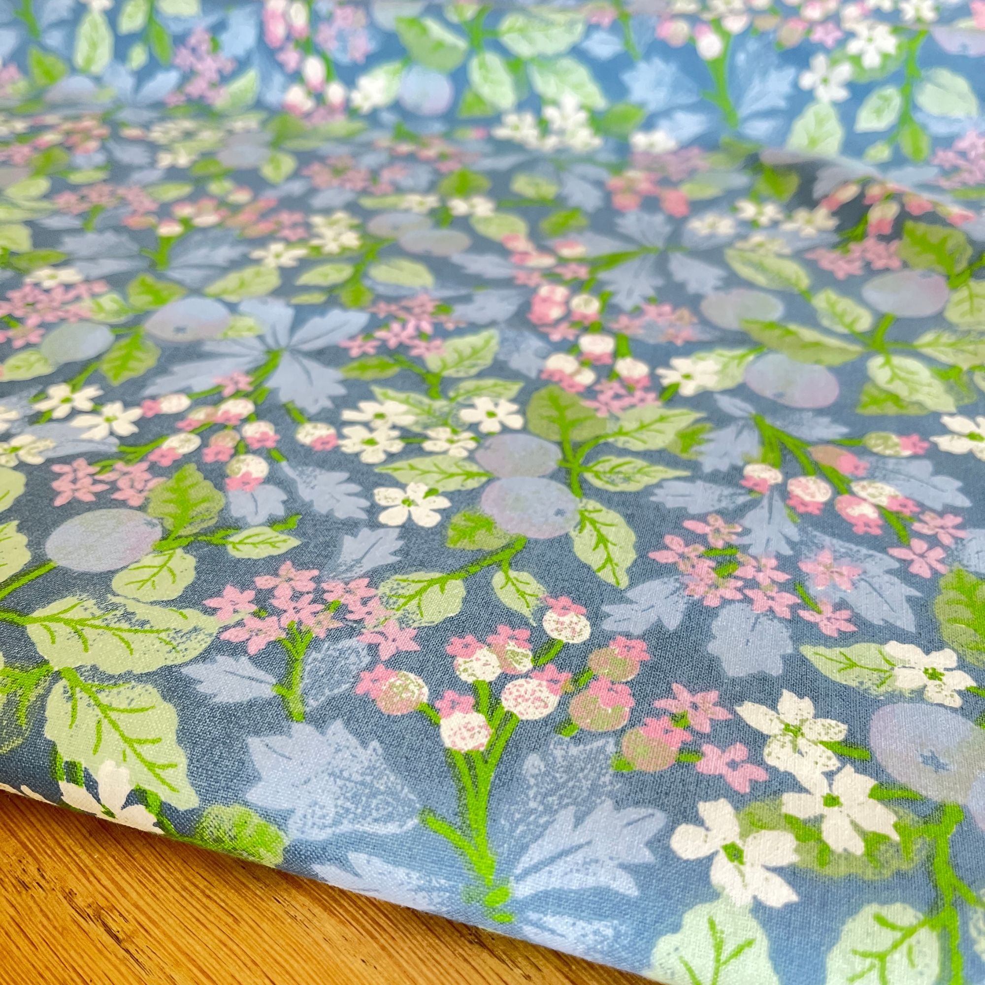 Katoen van de rol. Zomerse print, lichtblauwe bosbessen met roze, wit en groen, per 50 cm | 150 breed