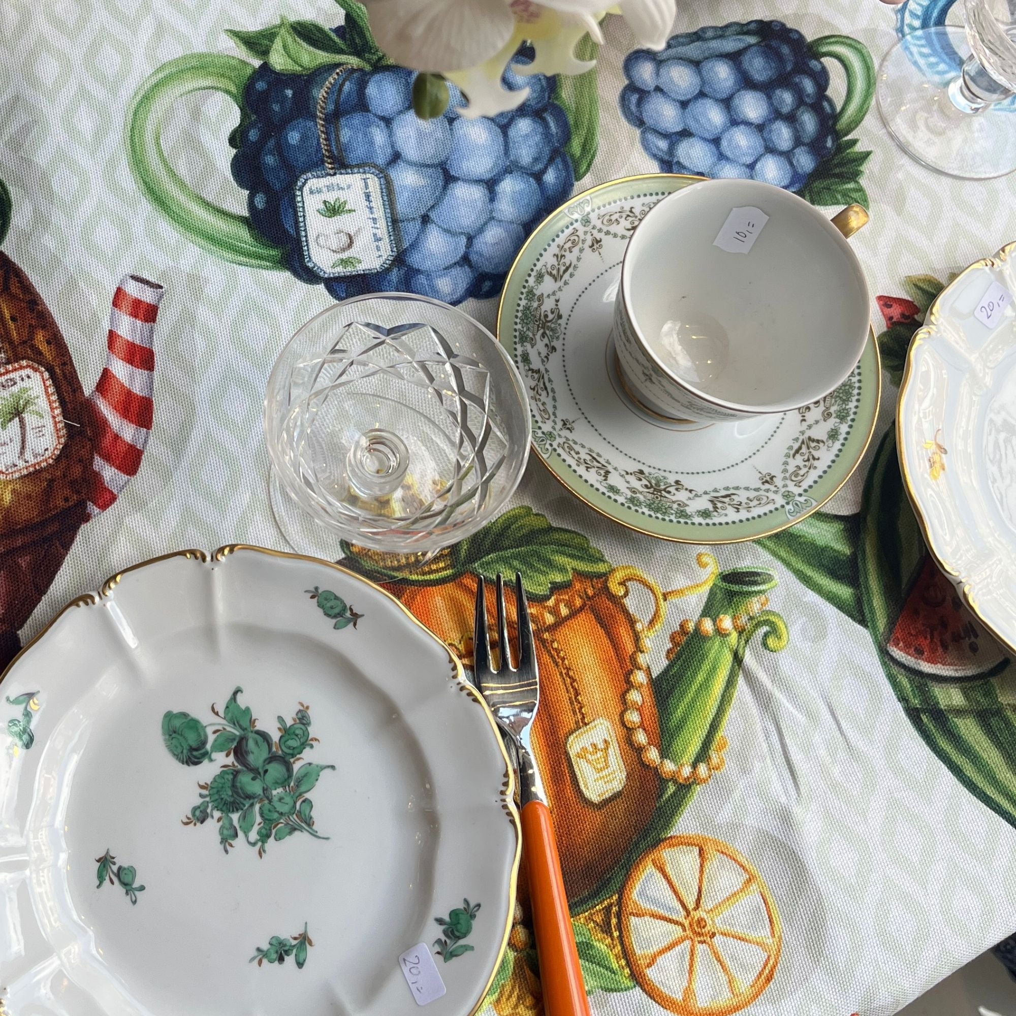 Stof Teabreak (voor een XL tafelkleed) met bonte theepotten en theekopjes op zachtgroen geometrisch patroon, katoen, per halve meter